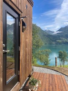 a door to a cabin with a view of a lake at Minihouse Stryn in Oppstryn