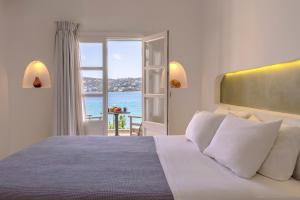 a bedroom with a bed with a view of the ocean at Alidian bay Suites Leros in Alinda