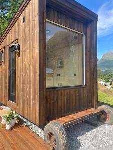 a wooden tiny house with a large window at Minihouse Stryn in Oppstryn +4 photos