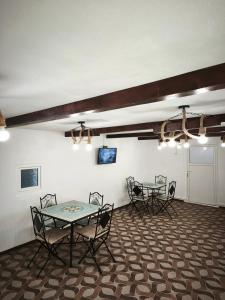 a room with a table and chairs and a tv at Bunătăți din Retezat in Nucşoara