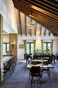 a dining room with tables and chairs and a chandelier at Rendezvous Heritage Hotel Queenstown in Queenstown