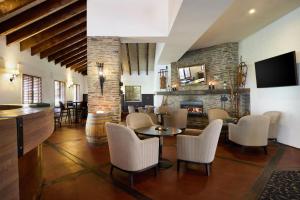 a living room with a table and chairs and a fireplace at Rendezvous Heritage Hotel Queenstown in Queenstown