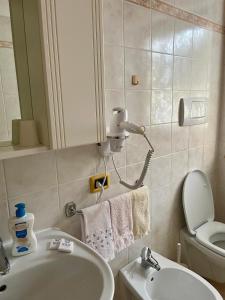 ein Badezimmer mit Waschbecken, Toilette und Spiegel in der Unterkunft Alpina depandance in Castello Tesino + 11 Fotos
