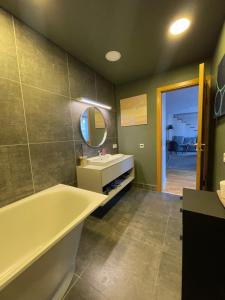 a bathroom with a tub and a sink and a mirror at Maironis 2 - Grand Apartment in the Heart of Kaunas in Kaunas +23 photos