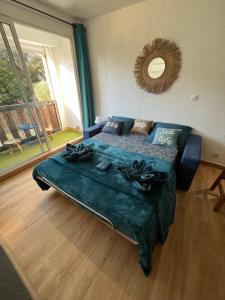 a bedroom with a blue bed and a large window at Charmant studio cabine in Cap d'Agde