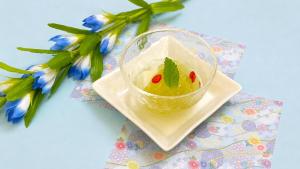 a bowl of ice cream on a plate next to flowers at 昆布川温泉幽泉閣 in Rankoshi