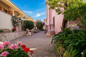 a cobblestone alley with flowers and buildings at Flowery Inn Villa in Alghero