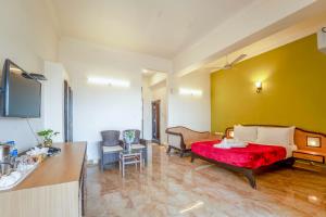 a hotel room with a bed with a red blanket at Calangute Residency in Calangute