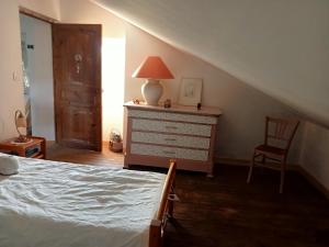 a bedroom with a bed and a dresser with a lamp at Chez Mekki in Châteauponsac