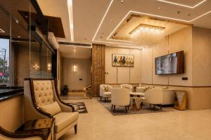 a lobby with a waiting room with chairs and a table at Four Leaf Hotel Dehradun in Dehradun