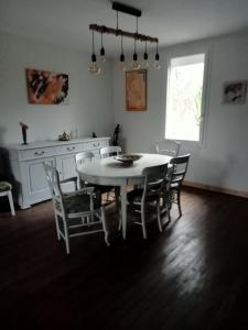 a dining room with a white table and chairs at Chez Mekki in Châteauponsac
