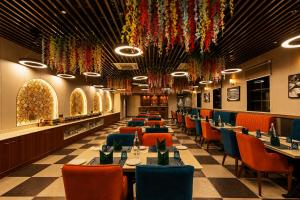 a restaurant with tables and chairs and colorful chandeliers at Four Leaf Hotel Dehradun in Dehradun