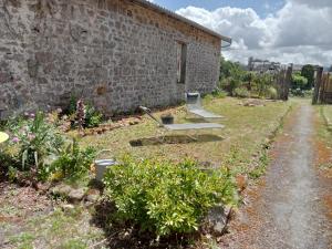 a garden with a stone wall and a bench at Chez Mekki in Châteauponsac
