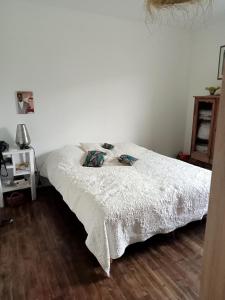 a bedroom with a bed with a white comforter at Chez Mekki in Châteauponsac +1 photo
