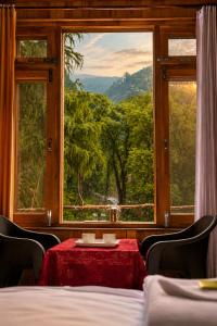 a room with a table and a large window at KOKILARIVERSONGHomesaty in Banjār