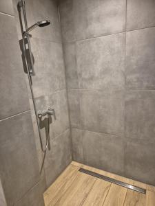 a shower stall with a shower head and a wooden floor at Hotel Elb Blick in Jork +9 photos