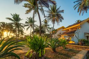 a house with palm trees in front of it at Calangute Residency in Calangute