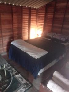 a bedroom with two beds in a wooden cabin at Weaver's Nest Backpackers Accommodation in Nyanda
