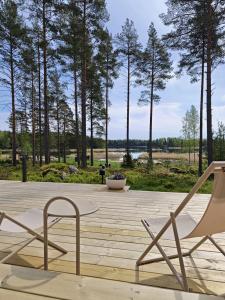 a couple of chairs sitting on a wooden deck at New Seaside Villa with Beach Sauna and Panoramic Views in Porvoo