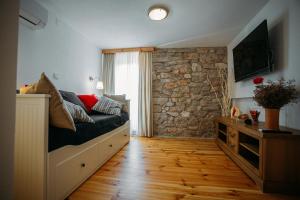 ein Schlafzimmer mit einem Bett und einer Steinwand in der Unterkunft Charming old stone house in Sali
