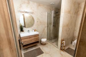 a bathroom with a shower and a sink and a mirror at Apartman Karlina 100 m2 Terrace Garden in Šahy +48 photos