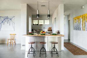 a kitchen with a large island with stools at Luxury Nature Retreat Villa Planchette in Lugano