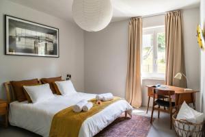 a bedroom with two beds and a desk and a window at Luxury Nature Retreat Villa Planchette in Lugano