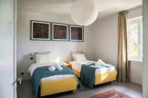 a room with two beds and a window at Luxury Nature Retreat Villa Planchette in Lugano