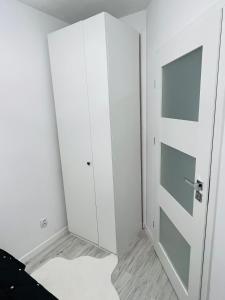 a room with white cabinets and a door at Apartament Borys in Malbork +2 photos