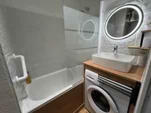 a bathroom with a sink and a washing machine at Charmant studio cabine in Cap d'Agde