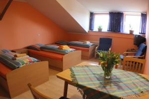 Zimmer mit 3 Betten und einem Tisch mit Vase in der Unterkunft Reiterhof Könning in Freren