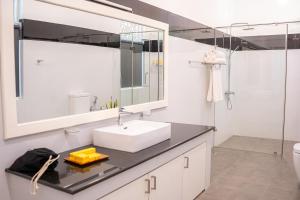 a white bathroom with a sink and a mirror at Villa Labugolla in Kandy +16 photos