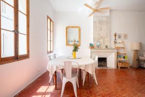 a dining room with a table with chairs and a mirror at Joli Cocon - Meublé de tourisme classé 2 étoiles - Terrasse - Parking in La Ciotat +25 photos