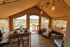 a dining room in a safari tent with a table and chairs at InMaremma glamping in Pescia Romana