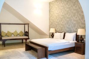 a bedroom with a bed and a bench in it at Villa Labugolla in Kandy
