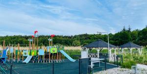 a park with a playground with a slide at Sunset Resort Apartament Marco Marina in Grzybowo