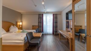 a hotel room with a bed and a desk at Geniesserhotel Messnerwirt Olang in Valdaora