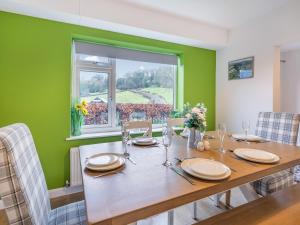 a dining room with a wooden table and a window at Carr View Farm in Bamford