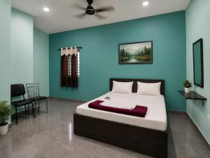 ein Schlafzimmer mit einem Bett und einer blauen Wand in der Unterkunft Prasant Inn in Bhubaneshwar