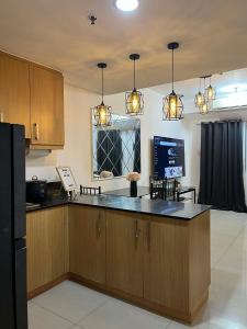 a kitchen with wooden cabinets and a black counter top at Shell Staycation in Manila