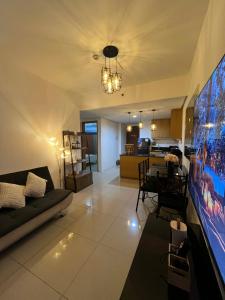 a living room with a couch and a large tv at Shell Staycation in Manila +6 photos