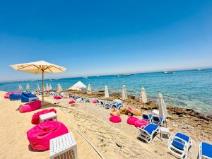 a beach with chairs and umbrellas and the ocean at Modern Front Seaview chalet El Sokhna in Ain Sokhna