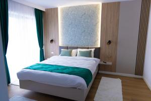 a bedroom with a large bed with a large window at Mira Montis in Borşa