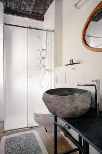 a bathroom with a stone sink and a toilet at Casa Martinelli, Boutique-Hotel in Maggia +14 photos