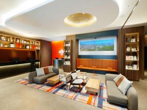 a living room with couches and a flat screen tv at Hotel Elcient Osaka Umeda in Osaka