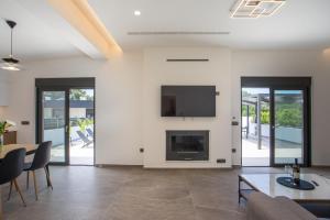 a living room with a fireplace and a tv at Casadi Fileri Villa in Ialysos