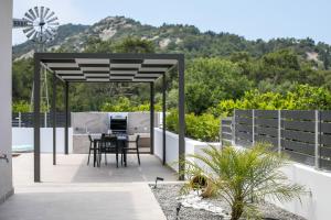 a patio with a table and a windmill at Casadi Fileri Villa in Ialysos