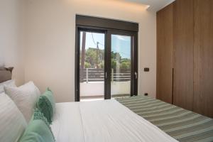 a bedroom with a bed and a glass door at Casadi Fileri Villa in Ialysos +57 photos