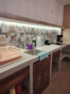 a kitchen with a sink and a counter top at Depas las Palmas in Zihuatanejo +8 photos