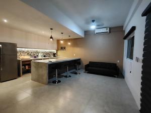 a kitchen with a counter and a couch in a room at Depas las Palmas in Zihuatanejo